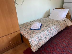 a small bed in a room with a pillow and a towel at LittleParadise100MFromTheBeach in Áyioi Apóstoloi