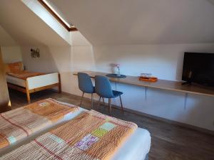 a bedroom with a bed and two chairs and a television at Haus Marika in Siófok