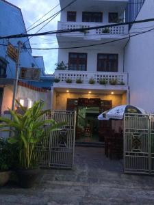 a building with a gate and a table and an umbrella at Gray Stone homestay in Hoi An