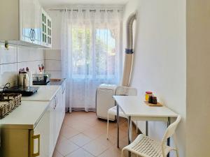 a kitchen with a small table and a white refrigerator at Apartman Radulovic in Negotin