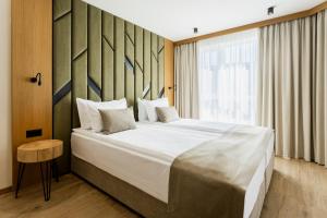 a bedroom with a large bed and a window at Natura All Seasons Boutique Hotel in Burgas City