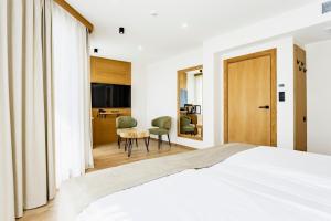 a bedroom with a bed and a table and chairs at Natura All Seasons Boutique Hotel in Burgas City +39 photos