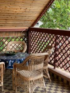 eine Terrasse mit einem Tisch und Korbstühlen in der Unterkunft Jókai 10 Vendégház Csongrád in Csongrád