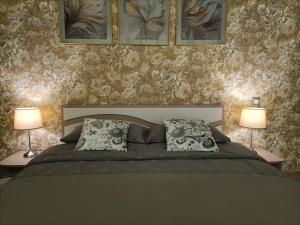 a bedroom with a large bed with two lamps at Apartamentai Šviesa 2 in Palanga