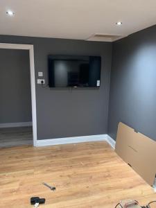 een kamer met een flatscreen-tv aan de muur bij CAS Apartment in Kilcullen