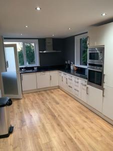 een grote keuken met witte kasten en een houten vloer bij CAS Apartment in Kilcullen