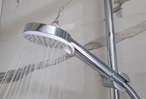 a shower with a shower head in a bathroom at Apartmаn Avram ll in Kotor-Varoš