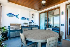 Un comedor con una mesa y una cocina. en Ocean View 2BD Retreat with Pool, en Puerto Vallarta