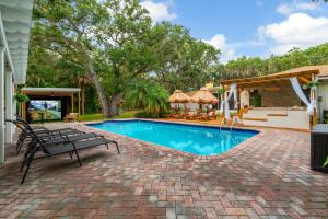 Una piscina con un banco al lado de una casa. en 9BR Heated Pool Hot Tub Sleeps 25, en Largo