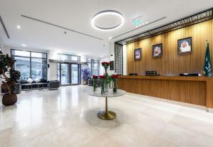 a lobby with a table with flowers on it at فندق السعفة الذهبية Assaafa Golden Hotel in Al Madinah