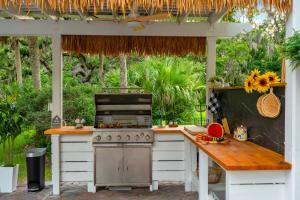 cocina al aire libre con fogones y mesa en 9BR Heated Pool Hot Tub Sleeps 25, en Largo