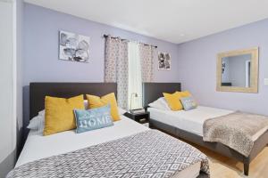 two beds in a room with blue walls and yellow pillows at 6 BR Pool Family Getaway near Coquina Beach in Bradenton +26 photos