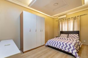 a bedroom with a bed and a white cabinet at Tastefully furnished 3 bedroom apartment in Lekki