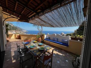 a table on a patio with a view of the ocean at Casa Angelica Positano in Positano