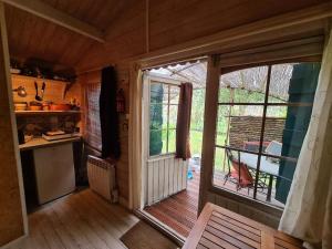 a kitchen with a sliding glass door to a porch at Le chalet du Jardin caché in Marmande