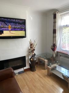 a living room with a flat screen tv on a wall at 35 Holborn road London E13 8PH Near EXCEL EXHIBITION CENTRE in London