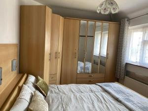 a bedroom with a bed and a large wooden cabinet at 35 Holborn road London E13 8PH Near EXCEL EXHIBITION CENTRE in London