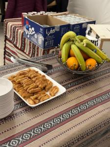 a table with two bowls of bread and bananas and oranges at Rum thabit camp in Wadi Rum