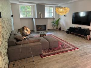 a living room with a couch and a flat screen tv at Klimaanlage, 5 Sterne Bahnhoftraum, 200qm Appartement "Waldzauber", 1200qm Garten, QR Code scannen für virtuellen Rundgang, Premium Ausstattung in Braunfels