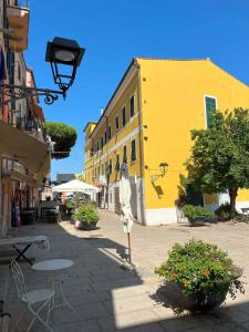 a street with a yellow building and tables and chairs at Via Scappini in Rio Marina