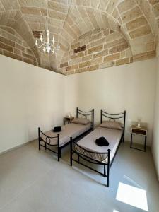 Dos camas en una habitación con techo de ladrillo. en Casa Zia Anna, en Torchiarolo