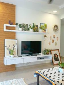 a living room with a tv on a white table at Tea Valley & Farm View at Cool Summer Cameron in Cameron Highlands