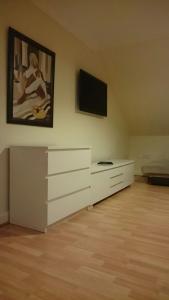 Habitación con vestidor blanco y TV de pantalla plana. en QuickSpaces Alexandra Apartments, en Mánchester