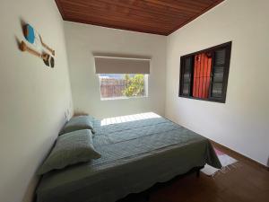 a bedroom with a bed and a window at Casa Aconchego in Ubatuba