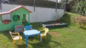 a backyard with a table and chairs and a play house at Waldapartment in Kranzlhofen