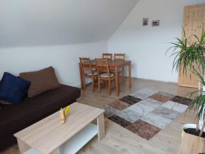 a living room with a couch and a table at Waldapartment in Kranzlhofen