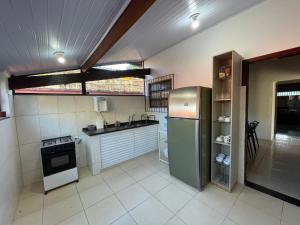 a kitchen with a refrigerator and a sink at Casa Aconchego in Ubatuba