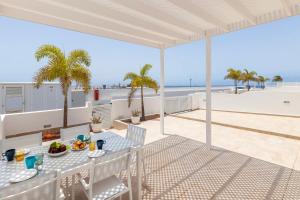 a patio with a table and chairs and a view of the beach at Villa Atlántica - Heated pool in Playa Blanca in Playa Blanca