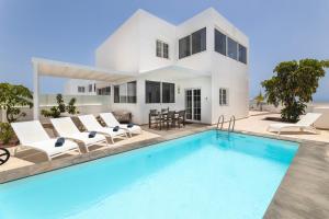 a villa with a swimming pool and a house at Villa Atlántica - Heated pool in Playa Blanca in Playa Blanca