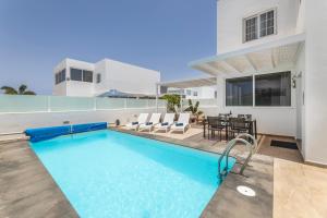 a house with a swimming pool and a table and chairs at Villa Atlántica - Heated pool in Playa Blanca in Playa Blanca