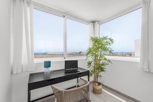 a desk with a laptop in a room with windows at Villa Atlántica - Heated pool in Playa Blanca in Playa Blanca