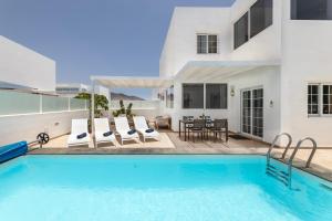 a villa with a swimming pool and a patio at Villa Atlántica - Heated pool in Playa Blanca in Playa Blanca