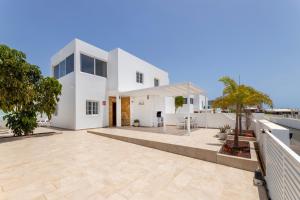a white house with a courtyard in front of it at Villa Atlántica - Heated pool in Playa Blanca in Playa Blanca