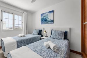 a bedroom with two beds with towels on them at Villa Atlántica - Heated pool in Playa Blanca in Playa Blanca