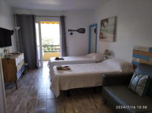 阿罗纳Appartamento los cristianos torres del sol的一间酒店房间，配有两张床和一张沙发