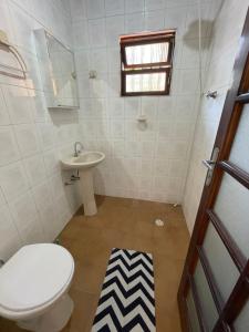 a bathroom with a toilet and a sink at Casa Aconchego in Ubatuba +4 photos