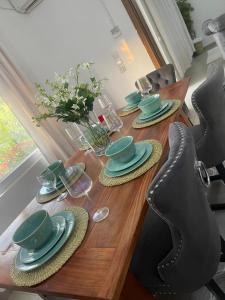 a wooden table with green dishes on top of it at Nashu Three bedroom Townhouse in Dambani