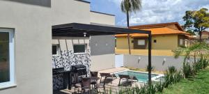 un patio con sedie e una piscina in una casa di Piscina com SPA - Check-in 9h - 70m da Represa a Palmeiras