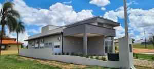 una casa con una recinzione bianca davanti di Piscina com SPA - Check-in 9h - 70m da Represa a Palmeiras