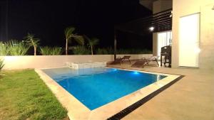 una piscina in un cortile posteriore di notte di Piscina com SPA - Check-in 9h - 70m da Represa a Palmeiras