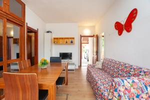sala de estar con sofá y mesa con una mariposa en la pared en Residence La Cinta, en San Teodoro