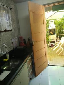una cucina con lavandino e una porta che conduce a un patio di Triplex 3 Suítes 10 PESSOAS Cond Aldeia dos Pescadores Praia do Forte a Praia do Forte Altre 9 foto