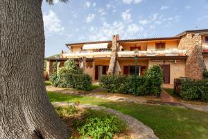 una vista exterior de una casa con un árbol en Residence La Cinta, en San Teodoro