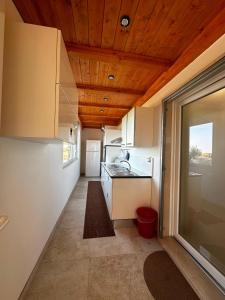 フランカヴィッラ・フォンターナにあるvilla Montiの白いキャビネットと木製の天井が備わるキッチン