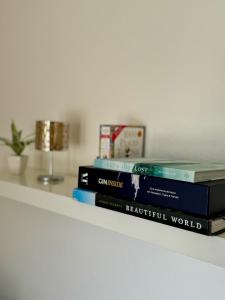 una pila de libros sentados en un estante en Stilvolles Business-Apartment mit Balkon in Leverkusen Wiesdorf - All-Inclusive Wohnen, en Leverkusen 9 fotos más