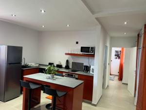 a kitchen with a refrigerator and a table with chairs at Magnifique T3 in Cayenne